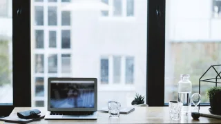 Laptop na biurku przy oknie — praca zdalna